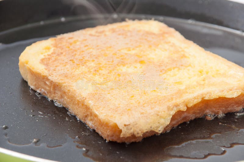 Bread Dipped in Egg and Placed in Hot Oil in a Frying Pan Stock Photo