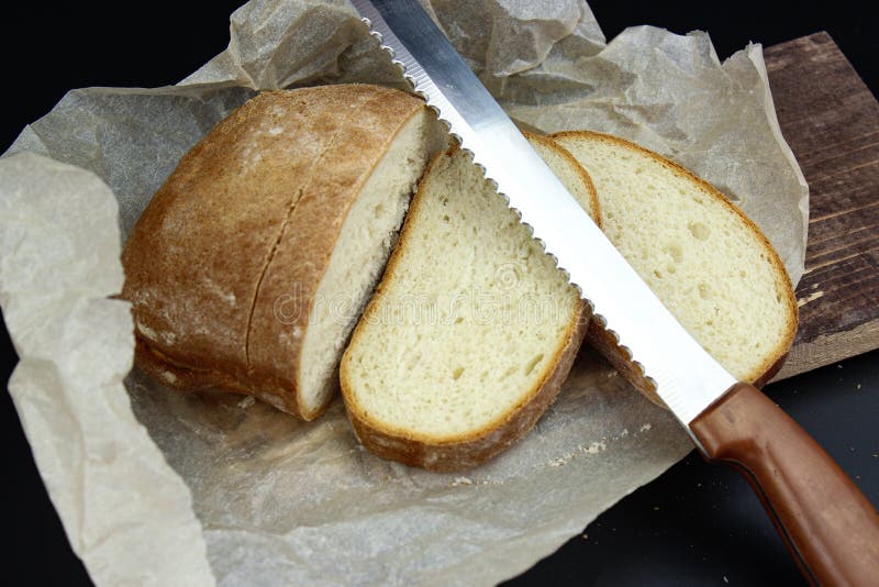 Bread Knife Slice. Sliced Bread on a Wooden Cutting Board and Knife