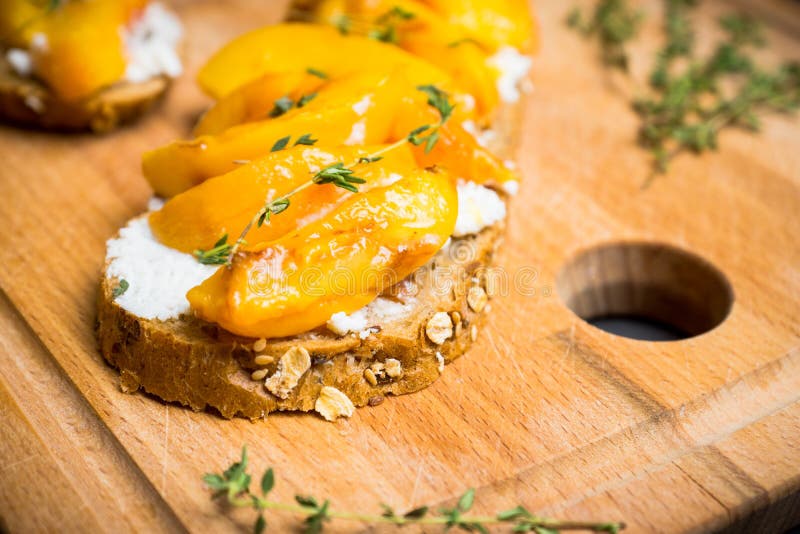 Bread with Ricotta Cheese and Grilled Peaches on the Rustic Background