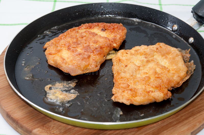 Breaded Chicken Breast On A Fork Stuck In Focus With A Plate In Stock