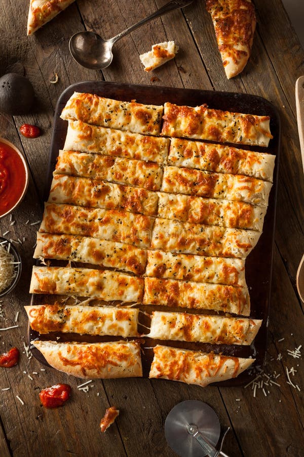 Breadsticks caseosos hechos en casa con Marinara fotografía de archivo libre de regalías Breadsticks caseosos hechos en casa con Marinara fotografía de archivo libre de regalías