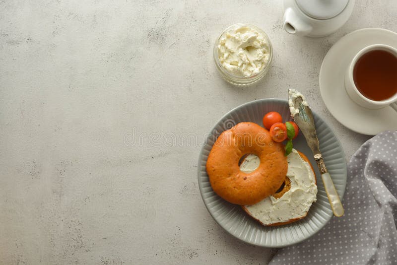 Breakfast with bagels and cheese, cherry, basil, tea cup. Healthy food. Copy space