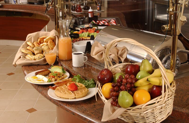 Colazione a buffet con uova, cialde, frutta e caffè.