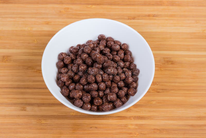 Breakfast Cereal Chocolate Balls in Bowl on a Wooden Surface Stock