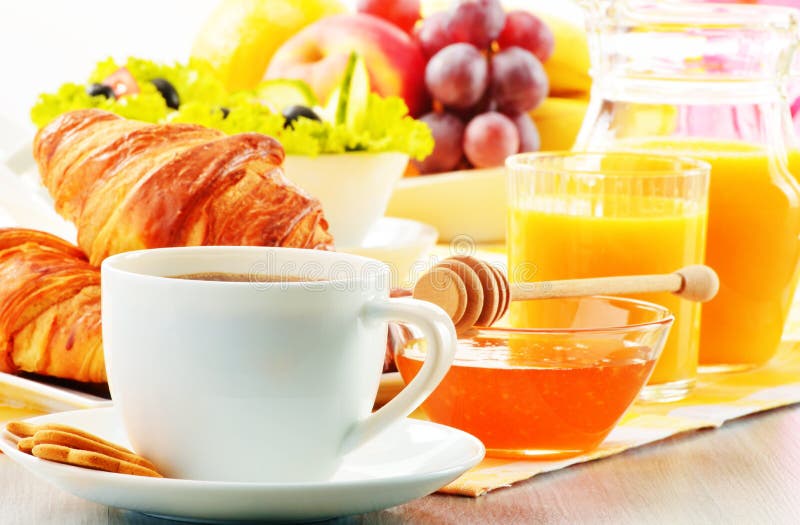 Breakfast with coffee, orange juice, croissant, egg, vegetables