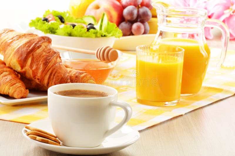 Breakfast with coffee, orange juice, croissant, egg, vegetables