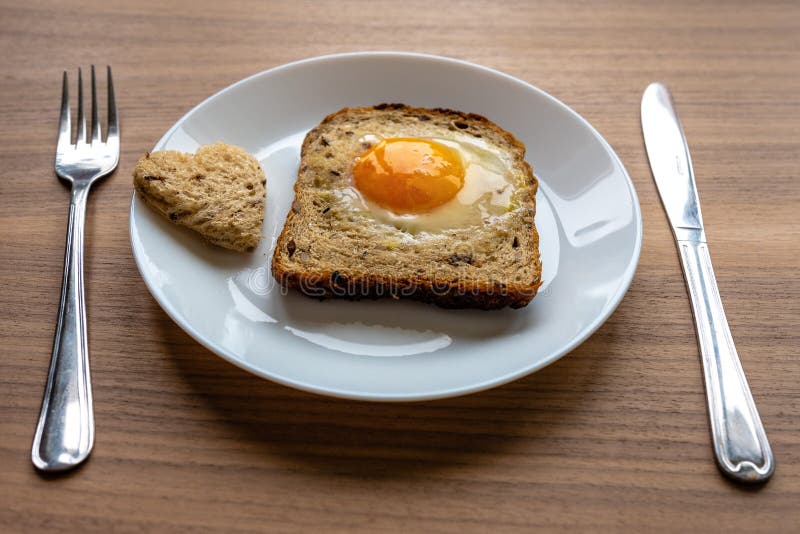 Breakfast Concept. White Plate with Hearts of Bread, Baked Bread and