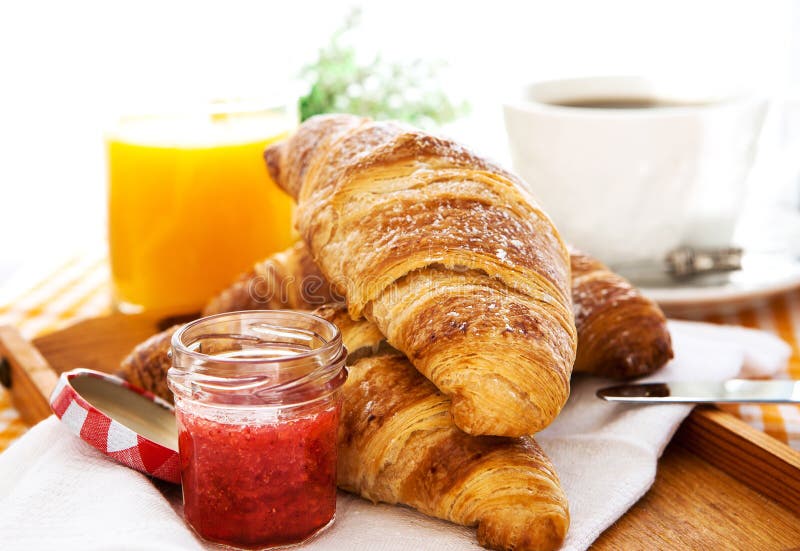 Breakfast with croissants, jam, cup of coffee and orange juice