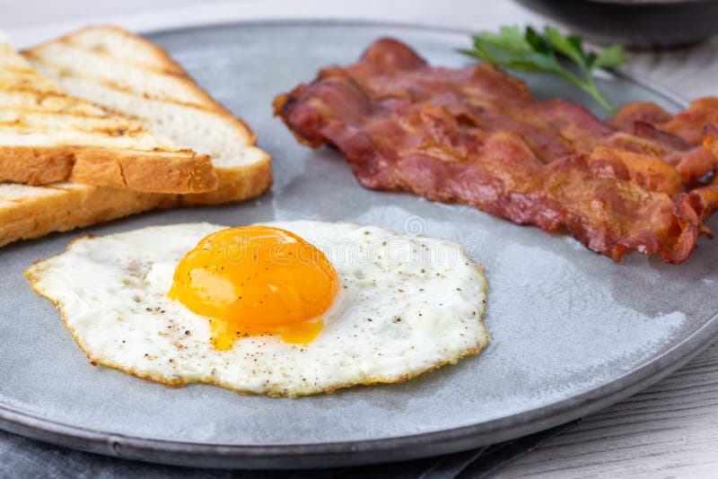 Breakfast Fried Bacon Pieces and Eggs on a Plate Stock Image Image