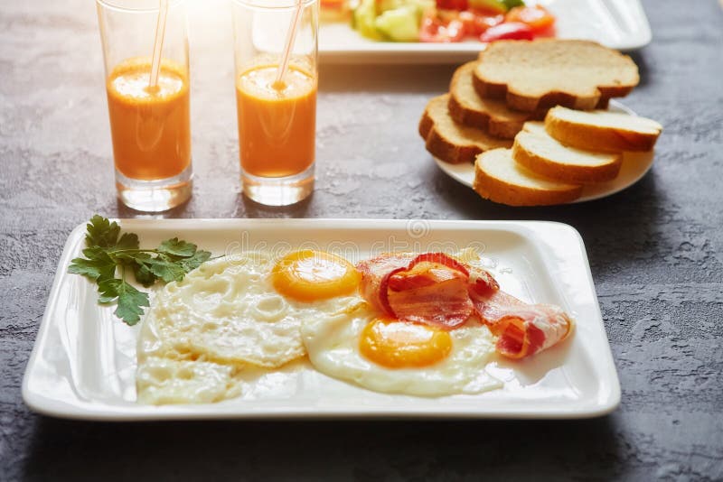 Daily Breakfast. Fried Egg with Bacon, Carrot Juice, Vegetable Salad