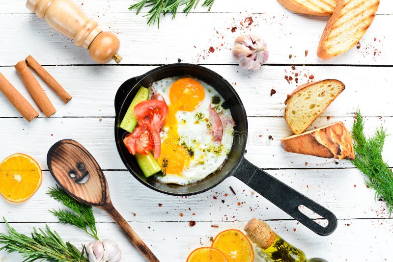 Breakfast. Fried Eggs with Bacon and Vegetables in a Frying Pan. Top