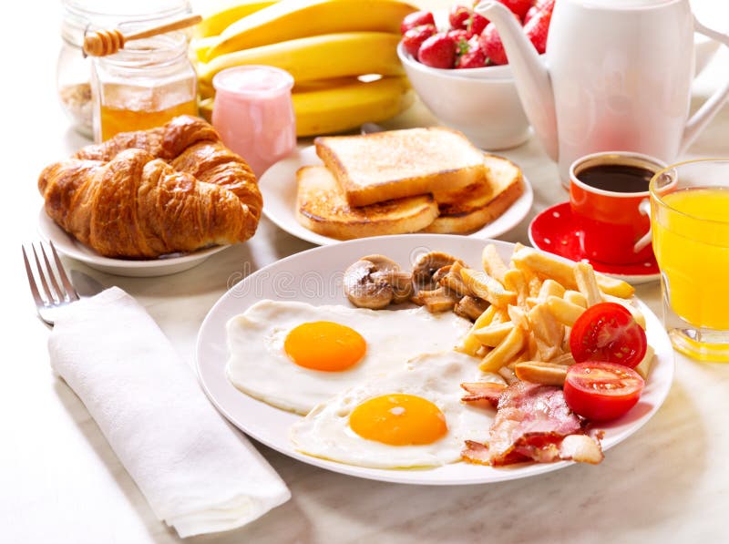 Breakfast with Fried Eggs, Coffee, Orange Juice, Toasts Stock Photo