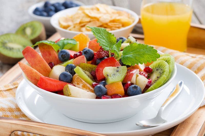 Breakfast with fruit salad, cornflakes and orange juice