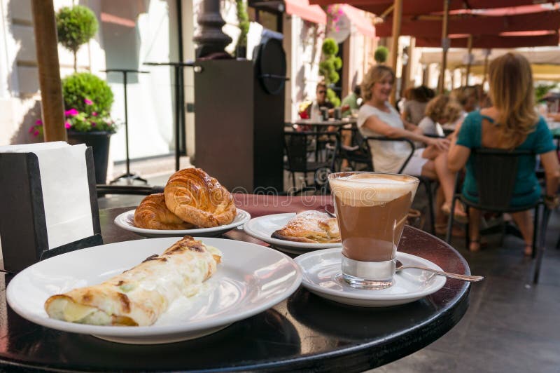 Breakfast meal with coffee and croissants served at outdoor restaurant in Italy