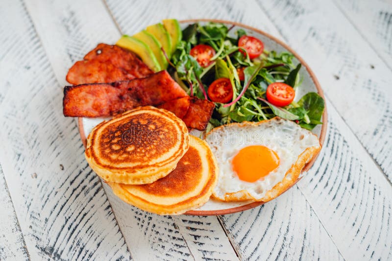 Breakfast Pancakes with Fried Eggs, Bacon and Mixed Salad Stock Image