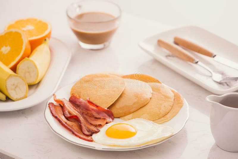Breakfast Plate with Pancakes, Eggs, Bacon and Fruit. Stock Photo