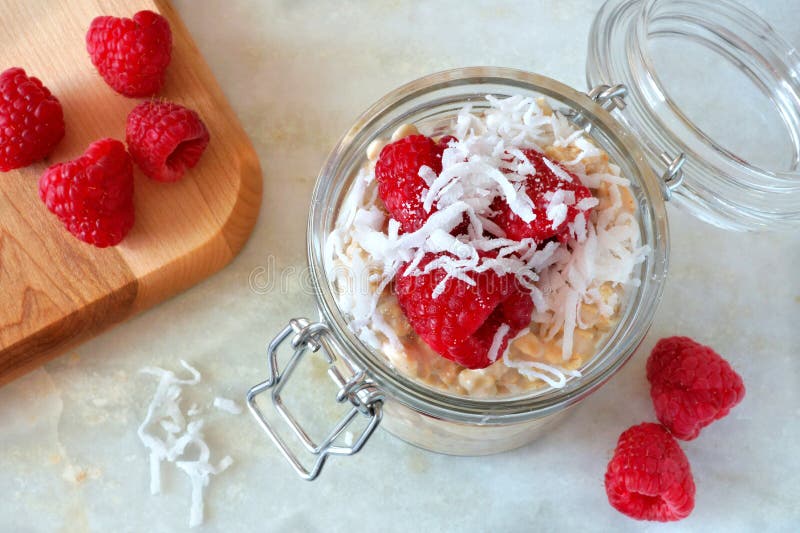 Breakfast refrigerator oatmeal with fresh raspberries and coconut stock photos