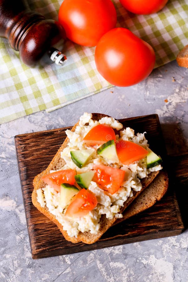 Breakfast with Scrambled Eggs and Fresh Vegetables on Bread Stock Photo
