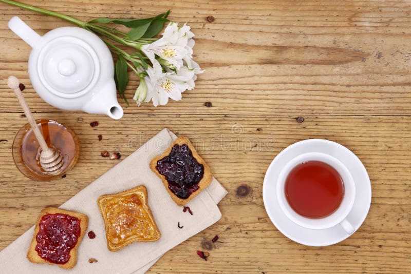 Breakfast Table with Tea, Teapot, Cup of Tea, Jam, Honey Stock Photo