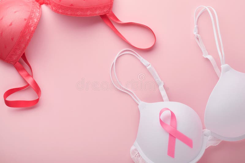 Girl wearing pink bra to examine their breasts. Stock Photo by ©poznyakov  89668104