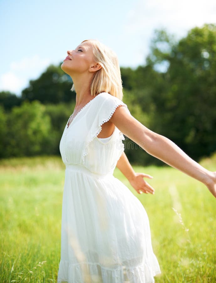 Breathing in and feeling free. Beautiful young woman savoring the breeze outdoors.