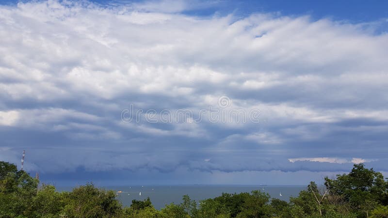 Breathtaking cloudscape above sea skyline with green foliage royalty free stock photos Breathtaking cloudscape above sea skyline with green foliage royalty free stock photos