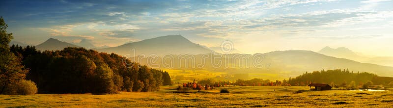 Breathtaking lansdcape of Austrian countryside on sunset. Dramatic sky over idyllic green fields of Anstrian Central Alps on autum