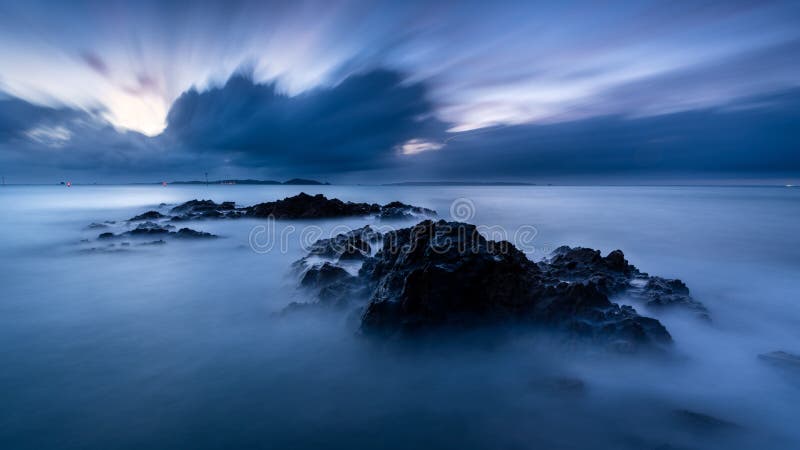 Breathtaking mysterious shot of rocks in the steamy sea stock image Breathtaking mysterious shot of rocks in the steamy sea stock image