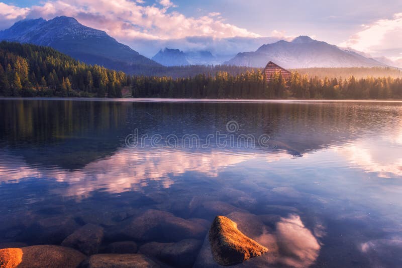 Úchvatný výhled na alpské jezero při východu slunce, mlhavá letní krajina, turistické středisko jezero štrbské pleso, vysoké tatry, slovensko