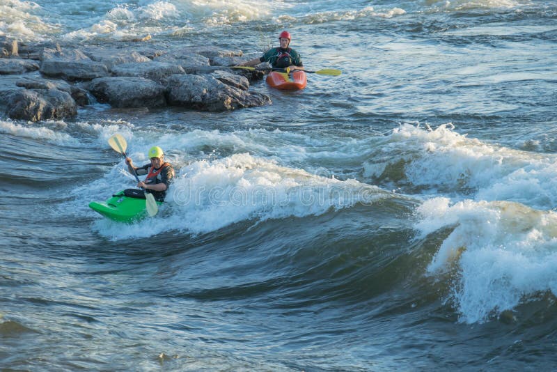 Missoula, Montana: 01 July 2014 - Man kayaking Brennan's Wave on the Clark Fork River and another waiting to try. Missoula, Montana: 01 July 2014 - Man kayaking Brennan's Wave on the Clark Fork River and another waiting to try