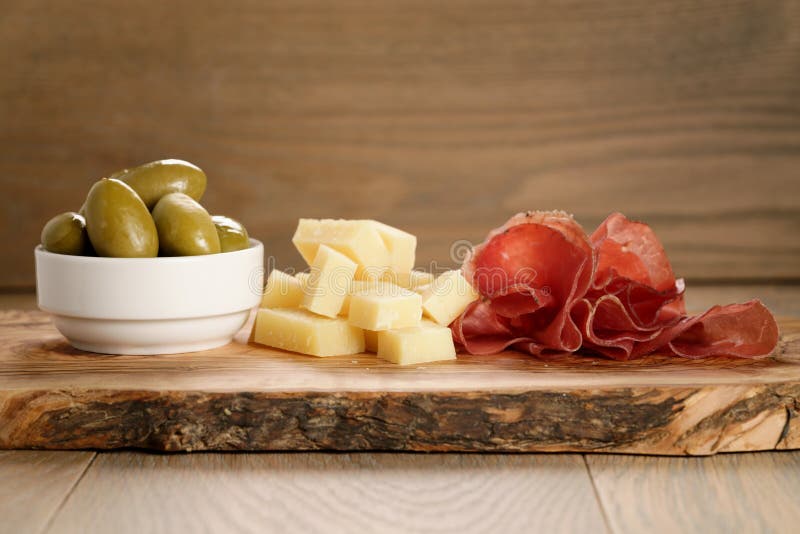 Bresaola con el queso parmesano y las aceitunas en tabla de cortar imagen de archivo libre de regalías Bresaola con el queso parmesano y las aceitunas en tabla de cortar imagen de archivo libre de regalías