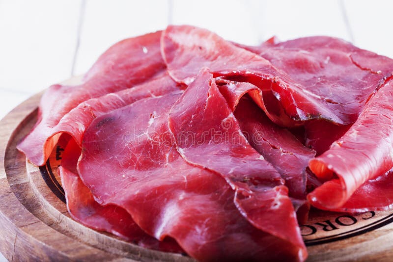 Bresaola over wooden plate stock photos Bresaola over wooden plate stock photos