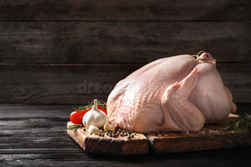 Brett mit rohem Truthahn und Bestandteilen auf Holztisch lizenzfreie stockfotografie Brett mit rohem Truthahn und Bestandteilen auf Holztisch lizenzfreie stockfotografie
