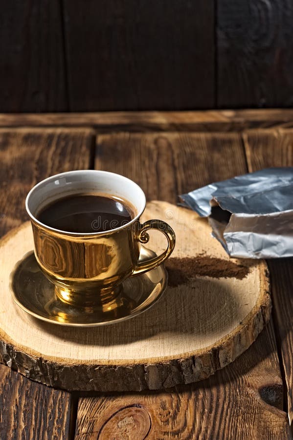 Brewed Black Coffee in a Golden Cup. Coffee Pot and Bag of Spilled