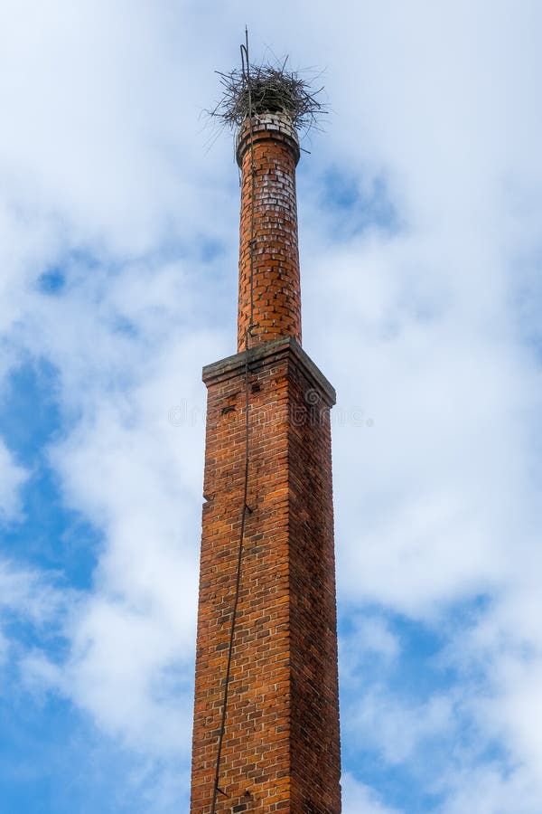 Brick chimney from an old abandoned factory with stork nest stock images