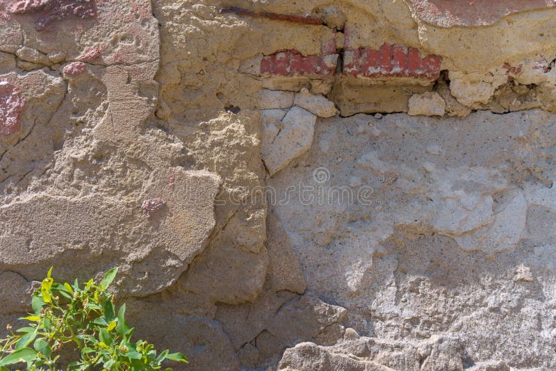 Brick city wall with falling off gray plaster. Destroyed and decaying under the influence of time and weather stock image Brick city wall with falling off gray plaster. Destroyed and decaying under the influence of time and weather stock image