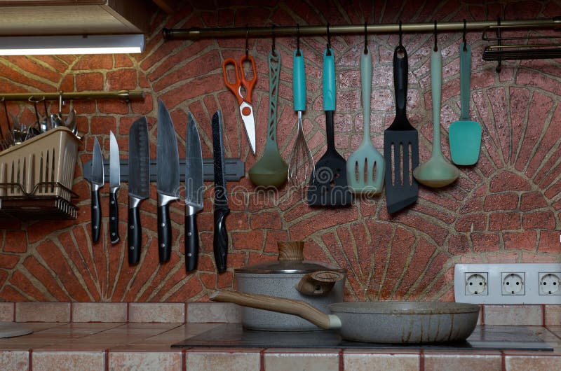 Brickdecorated Kitchen Wall with Kitchen Utensils Hanging on it Stock