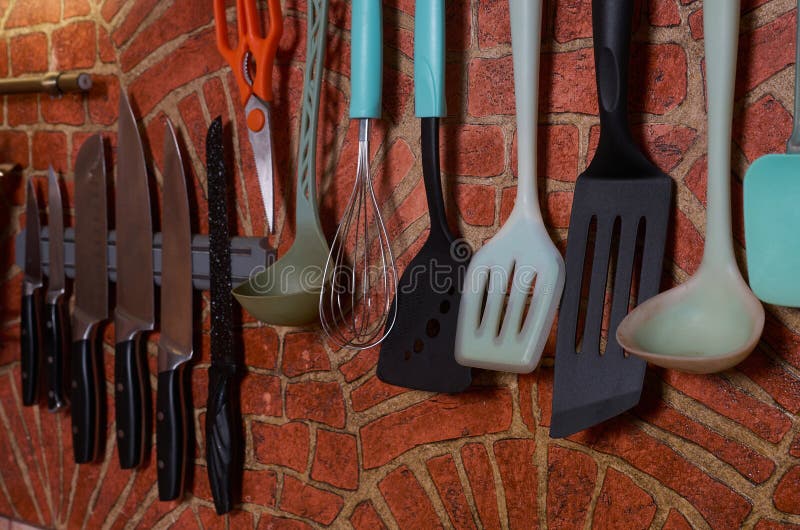 Brickdecorated Kitchen Wall with Kitchen Utensils Hanging on it Stock