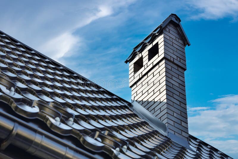 Brick Fireplace Chimney on the Roof and Clouds Blue Sky Stock Photo