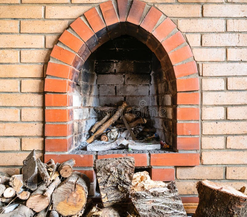 Brick Fireplace And Firewoods In The Village House Stock Photo