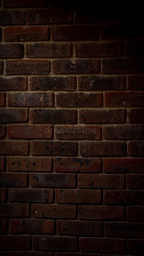 Brick Wall in an Alleyway Illuminated by Warm Lighting Stock Photo