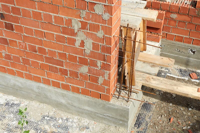 Brick wall construction in progress at a building site during daylight hours stock photography