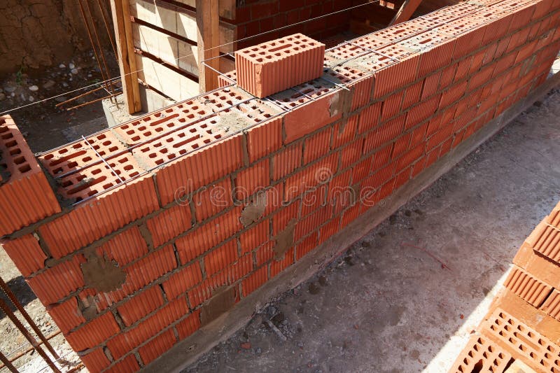 Brick wall construction in progress at a building site during daylight hours stock photos