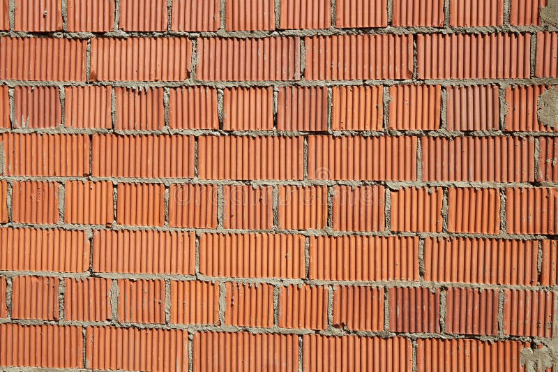 Brick wall construction with red clay bricks during daylight at a construction site stock photos