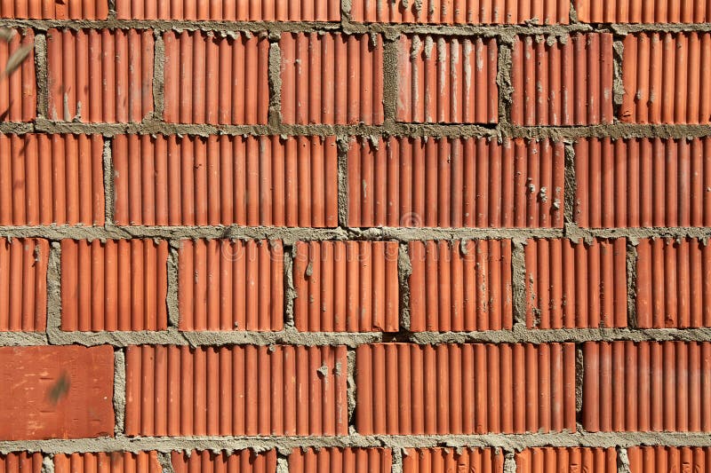 Brick wall construction with red clay bricks during daylight at a construction site stock photo