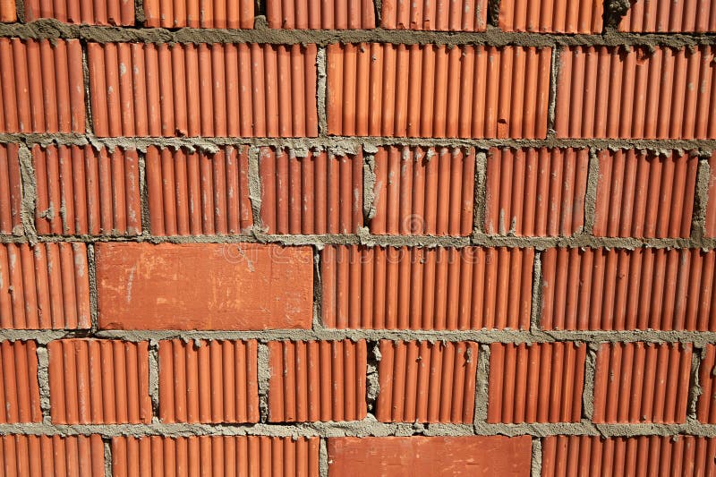 Brick wall construction with red clay bricks during daylight at a construction site stock image