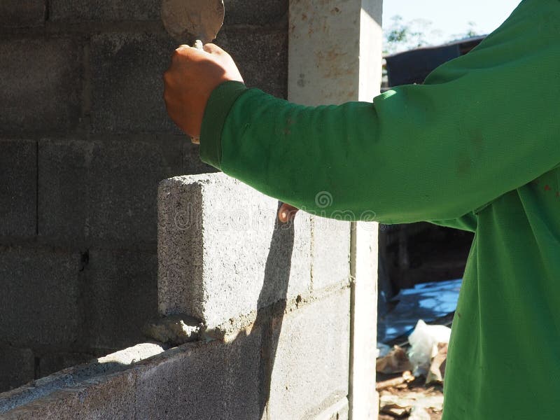 Bricklayer Laying Bricks and Measuring Brick Wall with Spirit Le Stock