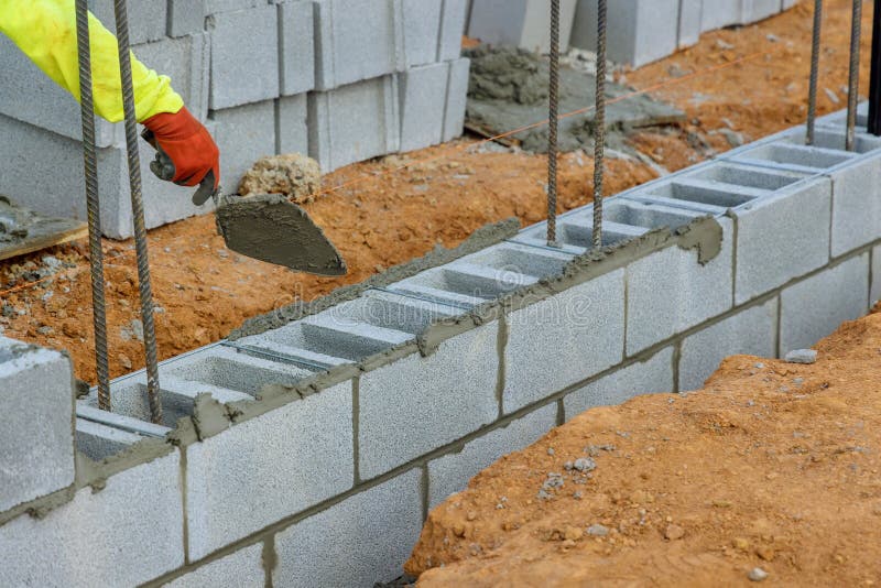A Bricklayer, a Mason, is Laying the Mounting for a Wall of Concrete