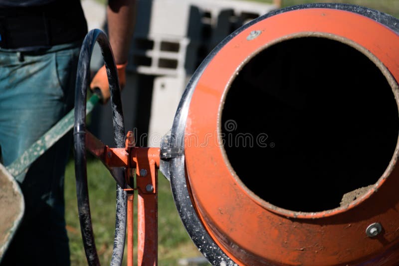 Bricklayer Preparing Concrete with a Cement Mixer To Build a Wall at a