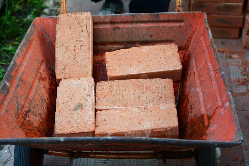 Construction Wheel Barrow with Pile of Gravel for House Foundation